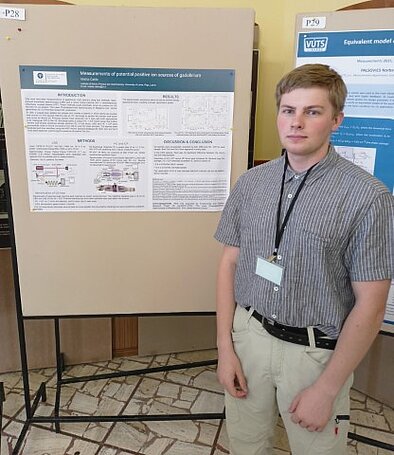 Matīss Čakšs blakus savam konferences plakātam