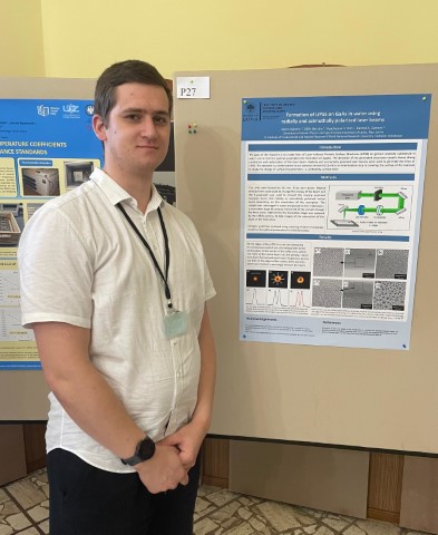 Kalvis Kalniņš blakus savam konferences plakātam